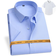 Light blue dress shirt with a white shirt inset and a measuring tape at the bottom on a light gray background.