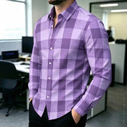 A man wearing a purple and lavender checkered long-sleeve button-down shirt in an office environment.