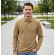 Beige long-sleeve polo shirt with a brand logo on a hanger against a background of other colored shirts.