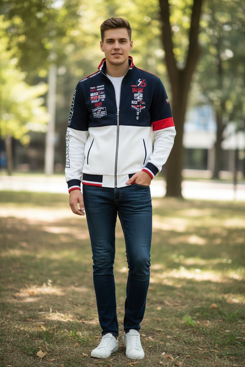 A men's zip-up track jacket with a color-blocked design in navy blue, white, and red. The jacket features graphic prints with 'SHARK' and racing-style details on the front and sleeves, and 'TACE&SHARK' branding on the left chest and sleeve.