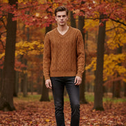 Brown cable knit sweater on a hanger against a light gray background