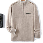 Beige quarter-zip mock-neck sweater with a chest pocket, displayed against a white background with a wooden hanger visible behind the collar.