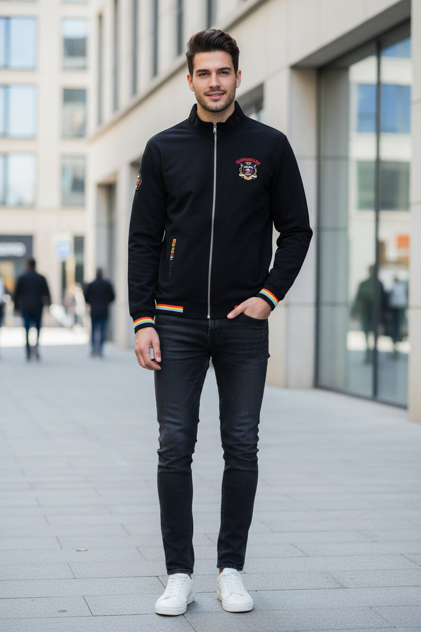 A black zip-up bomber jacket with colorful striped ribbed cuffs and hem, featuring a 'Cruel Shark' graphic on the left chest and a vertical 'TOY ALIVE' print on the right sleeve. The jacket is displayed on a clean white background with the TACE&SHARK brand logo in the top-left corner.