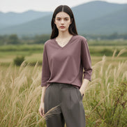 Person wearing a brown long-sleeve t-shirt against a neutral background