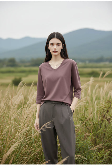 Person wearing a brown long-sleeve t-shirt against a neutral background