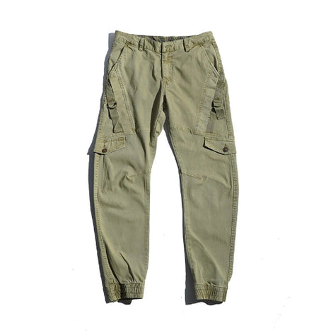 Light khaki cargo pants laid flat against a white background, showing angled thigh pockets, buttoned flap pockets, side straps, and gathered ankle cuffs.