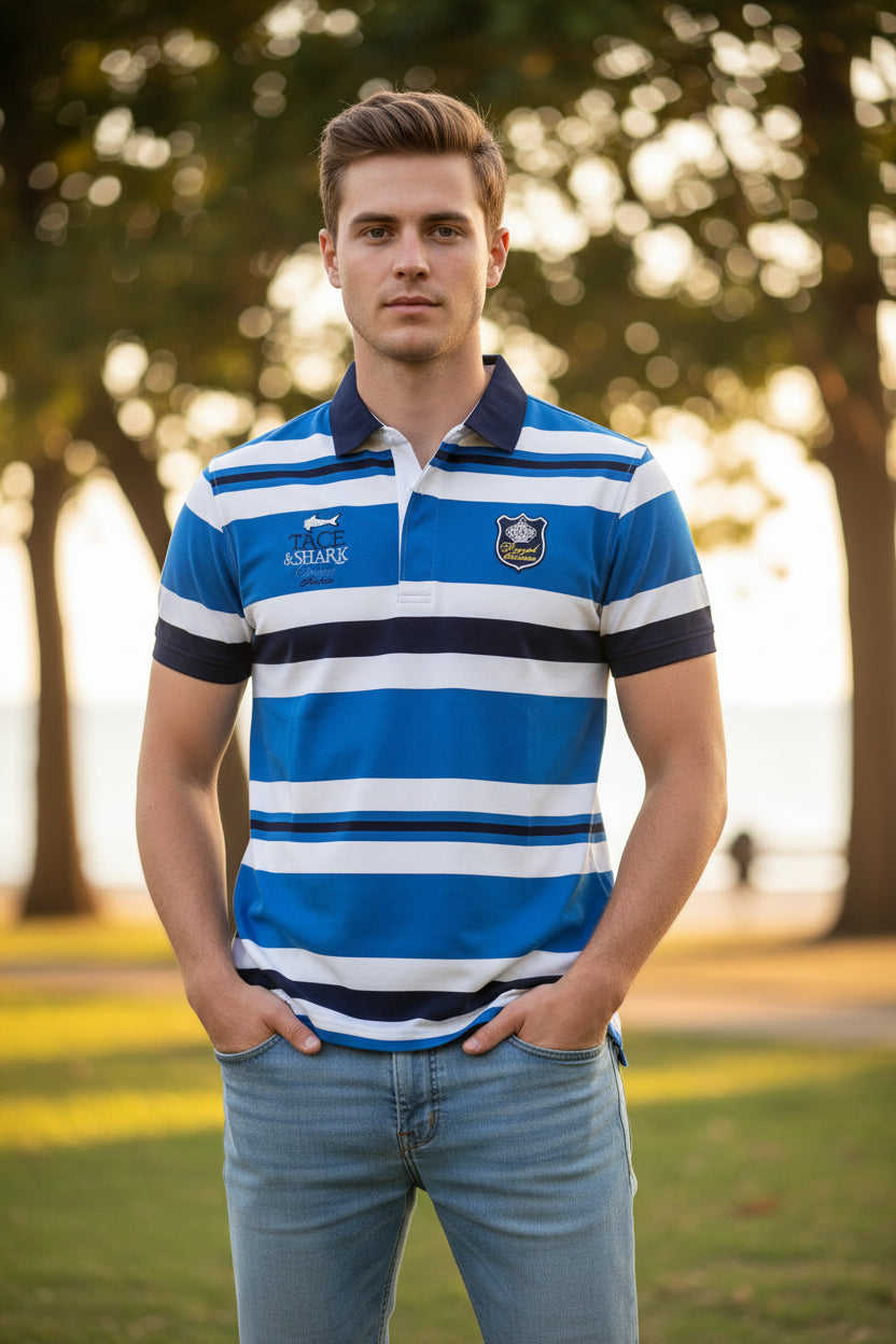 A short-sleeve striped polo shirt in blue, white, and navy, featuring a collar, a three-button placket, and various graphic logos on the chest. The brand 'TACE&SHARK' is visible both on the shirt's left chest and as a logo overlay in the top-left corner.