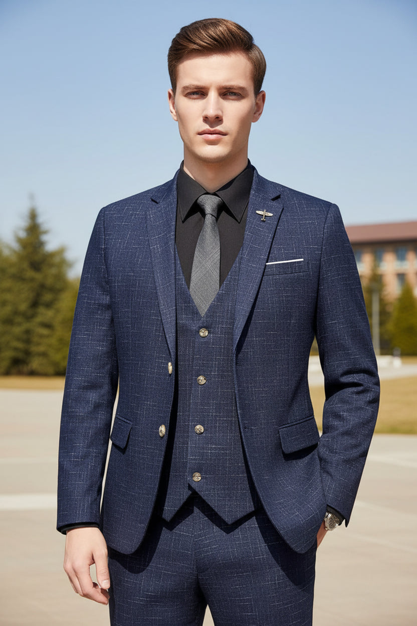 Man wearing a blue checkered suit with a gray tie indoors.