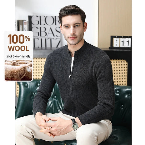 Man wearing a dark gray zip-up sweater sitting on a green couch with text about 100% wool and skin-friendliness.