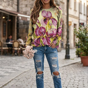 A woman wearing a long-sleeve crewneck sweatshirt with a large watercolor-style tulip print 