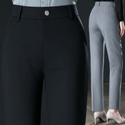 Close-up of black pants with a button and a person wearing gray pants.