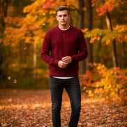 Red knitted sweater in a black box with a silver watch on a dark surface
