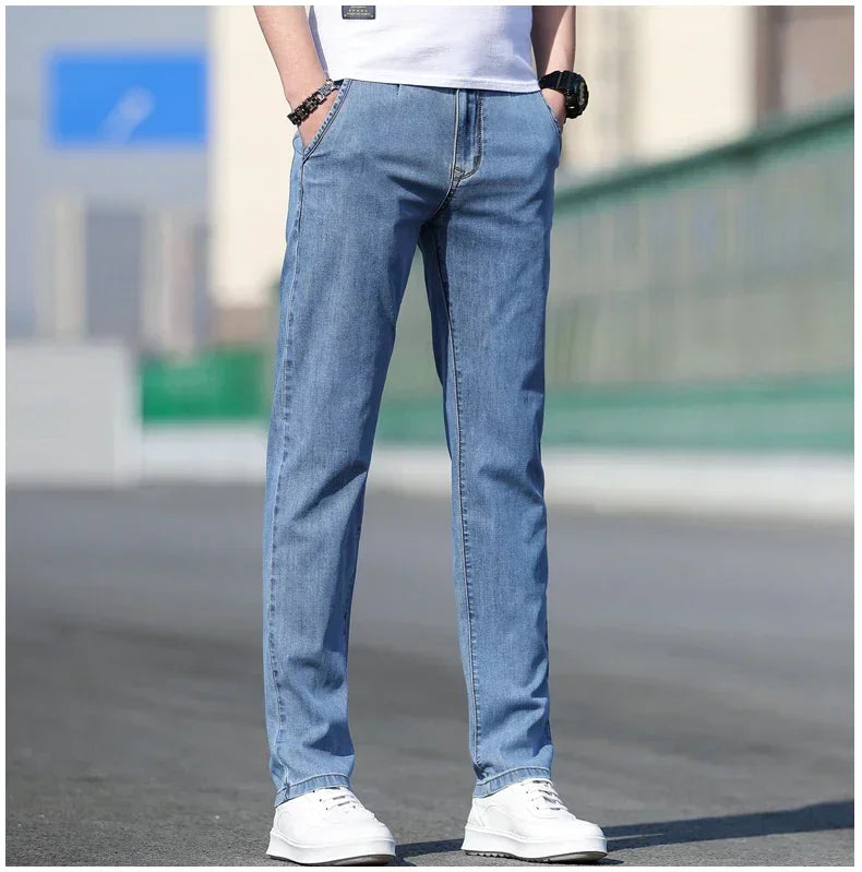 Person wearing light blue jeans and white sneakers on a blurred background