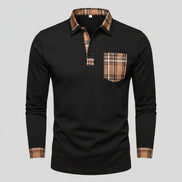 Man wearing a black long-sleeve polo shirt with plaid accents on a city street.