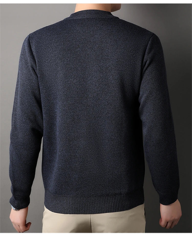 Dark blue sweater worn by a person on a gray background