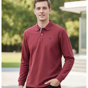 Red long-sleeve polo shirt with a small logo on a hanger against a background of other shirts.