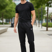 Black pants with a small logo on a textured concrete surface