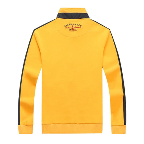 Yellow sweatshirt with black stripes on sleeves and collar, featuring a brand logo on the back, on a white background.