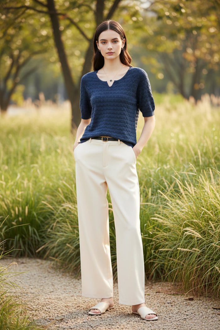 Woman wearing a blue textured sweater with a blurred outdoor background