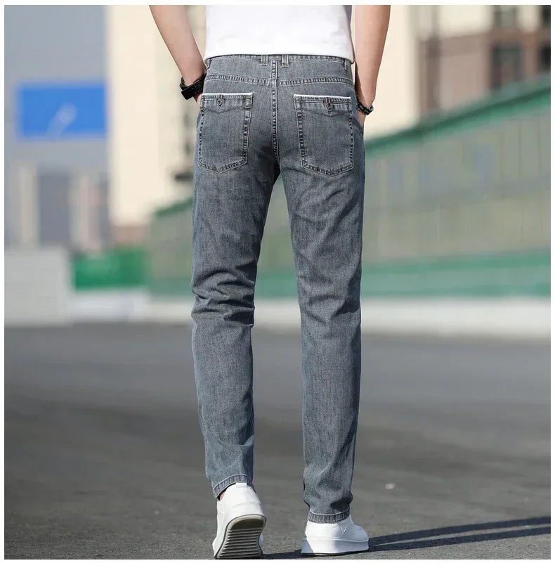 Person wearing gray jeans standing on a road with a blurred background