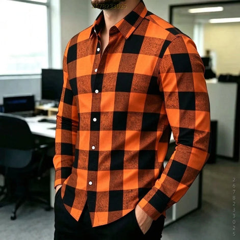 A man wearing a long-sleeve button-up shirt with a bold orange and black buffalo check pattern, standing in an office environment.