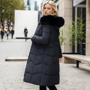 Woman wearing a black puffer coat with fur hood in an urban setting