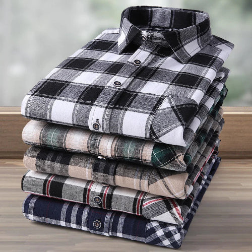 Stack of folded plaid shirts on a wooden surface with a blurred background