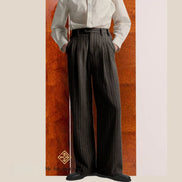 Person wearing a white shirt and dark pinstripe pants against a wooden panel background