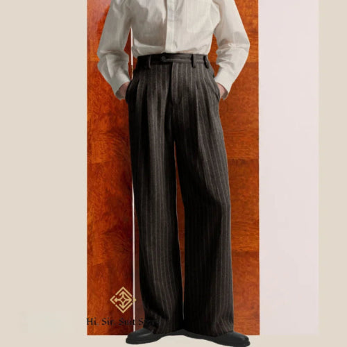 Person wearing a white shirt and dark pinstripe pants against a wooden panel background
