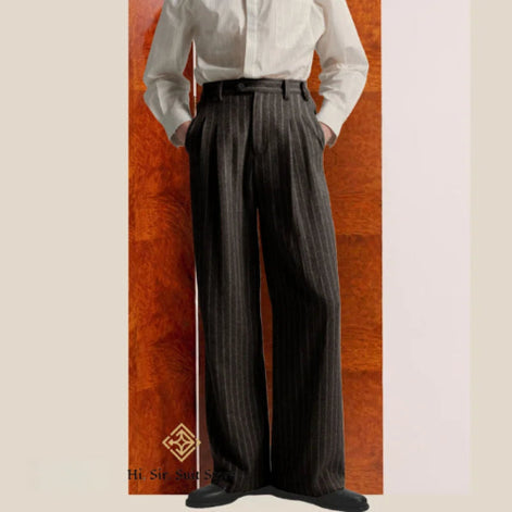 Person wearing a white shirt and dark pinstripe pants against a wooden panel background