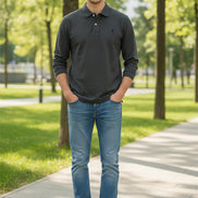 Gray polo shirt with brand logo held by a hand, with other shirts in the background.