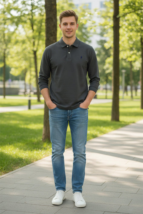Gray polo shirt with brand logo held by a hand, with other shirts in the background.