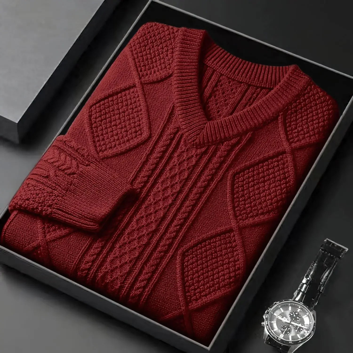 Red knitted sweater in a black box with a silver watch on a dark surface
