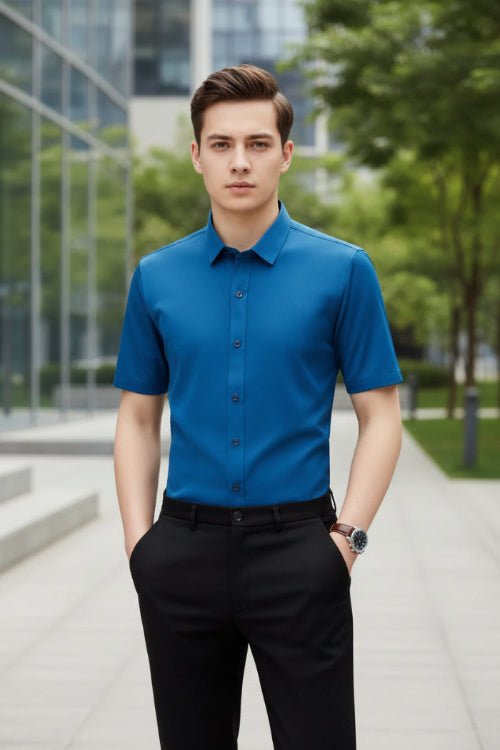 Person wearing a blue short-sleeve shirt against a gray background