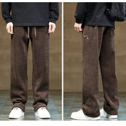 Brown corduroy pants worn by a person on a tiled floor with a neutral background