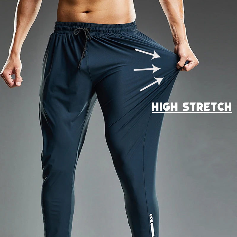 Navy blue athletic pants with 'High Stretch' text and arrows on a gray background
