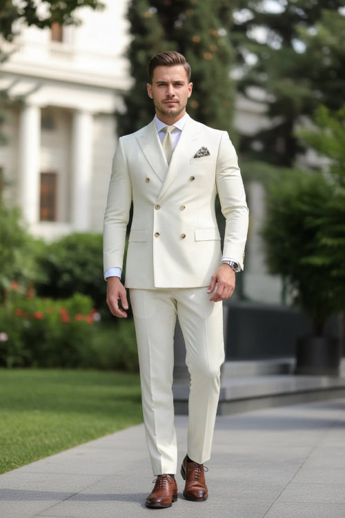 Man wearing a cream double-breasted suit with a blurred green background