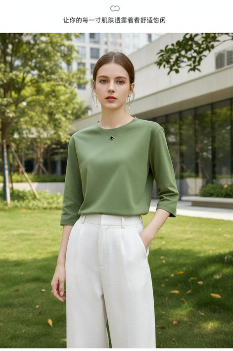 Person wearing a green top and white pants against a neutral background