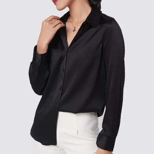 Black silk shirt worn by a model with white trousers.