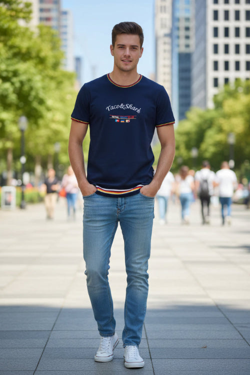 A navy blue short-sleeve t-shirt with 'Tace&Shark' and 'Royal Racing Club' embroidered on the chest, featuring red and yellow striped trim on the collar, cuffs, 