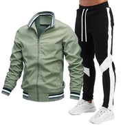 A men's two-piece tracksuit set featuring an olive green zip-up bomber jacket with striped ribbed trim and black track pants 