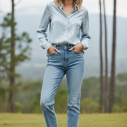 Person wearing a light blue leopard print shirt against a plain background