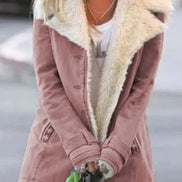 Woman outdoors wearing a dusty rose coat with wide cream fleece-look lapels, front pockets and cuff tabs over a white top
