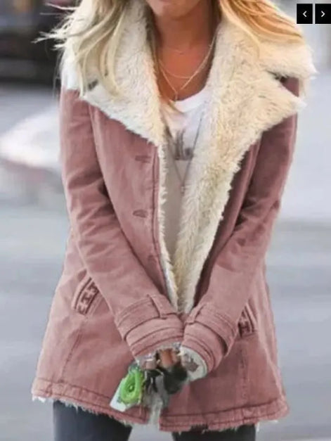 Woman outdoors wearing a dusty rose coat with wide cream fleece-look lapels, front pockets and cuff tabs over a white top
