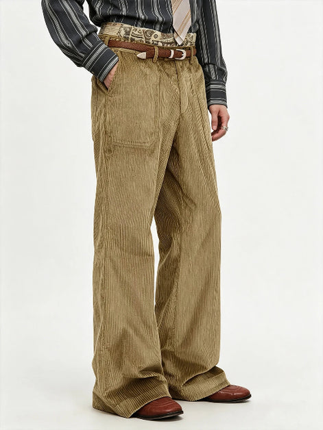 A person wearing wide-leg tan corduroy trousers with a brown belt, a striped shirt, and brown shoes, photographed against a plain light background.