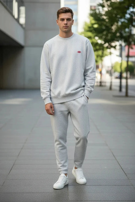 Person wearing a white sweatshirt with a small red logo on a light gray background
