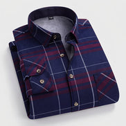 A folded men's long-sleeve button-up shirt with a navy blue base and burgundy and white plaid pattern, featuring a soft gray fleece lining. 