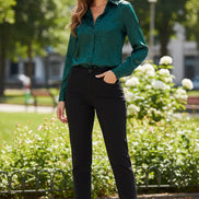 Woman wearing a green patterned blouse against a plain background