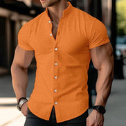 Man wearing an orange short-sleeve shirt with a blurred background