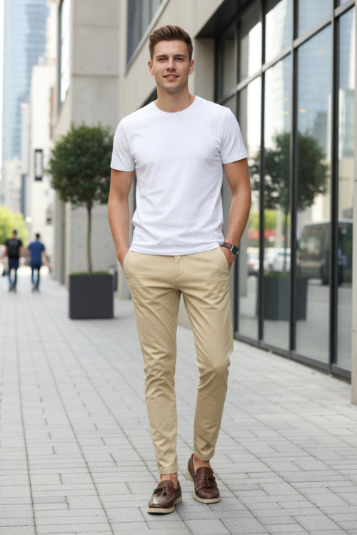Person wearing beige pants and brown shoes on a plain background